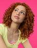 A woman with vibrant, bouncy curls from using NYM Curl Talk products.