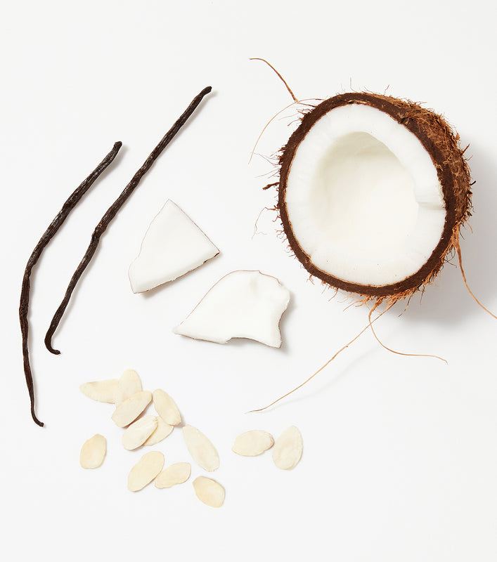 A close-up of natural coconut and almond ingredients used in NYM hair care products.